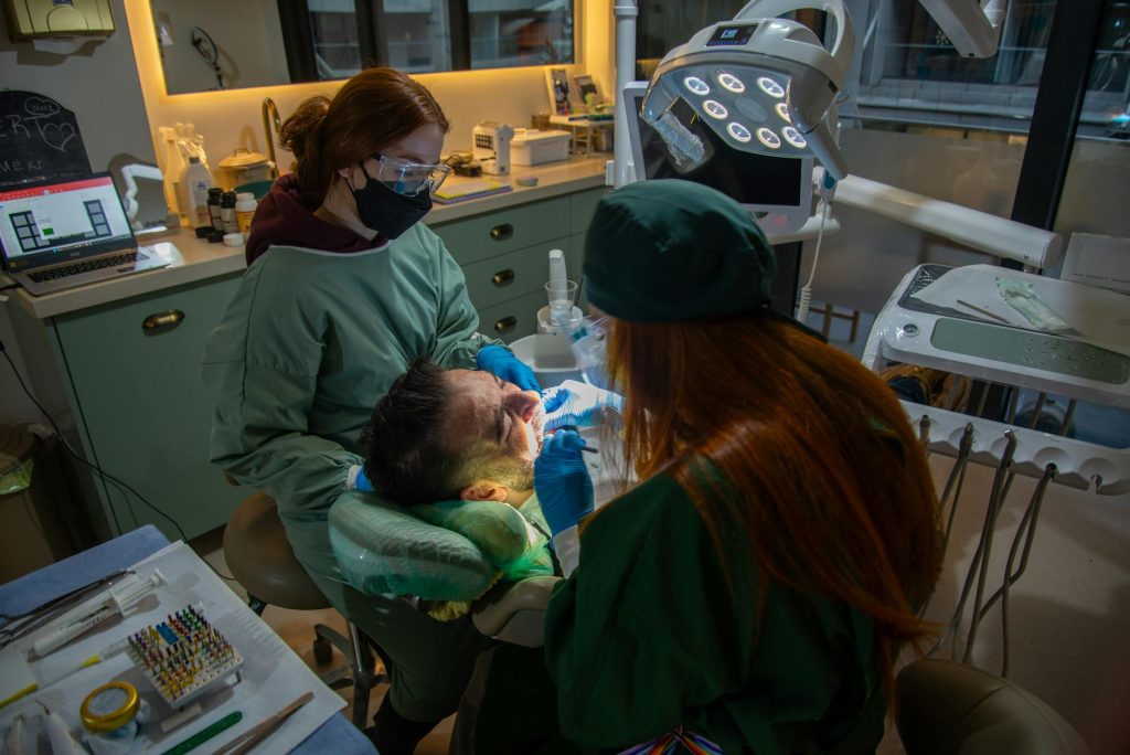 dentist and her assistant treating a male patient